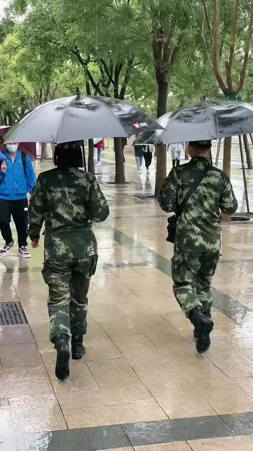大雨中游客纷纷帮执勤武警战士撑伞